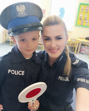 Policjantka podczas zajęć profilaktycznych z dziećmi w przedszkolu ELEMELEK , na terenie gminy Czosnów. st. sierż. Sylwia Ochmańska przybliża przedszkolakom zasady bezpieczeństwa oraz prezentuje sprzęt policyjny.
