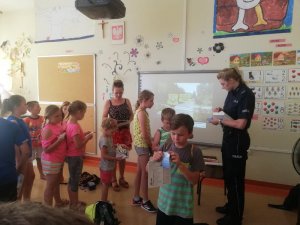 St. sierż. Sylwia Ochmańska podczas spotkania z dziećmi na półkoloniach w Leoncinie. Policjantka omawia tematykę bezpieczeństwa nad wodą.