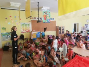 St. sierż. Sylwia Ochmańska podczas spotkania z dziećmi na półkoloniach w Leoncinie. Policjantka omawia tematykę bezpieczeństwa nad wodą.
