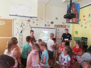St. sierż. Sylwia Ochmańska podczas spotkania z dziećmi na półkoloniach w Leoncinie. Policjantka omawia tematykę bezpieczeństwa nad wodą.