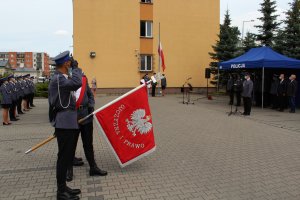 policjanci podnoszą na maszt flagę państwową