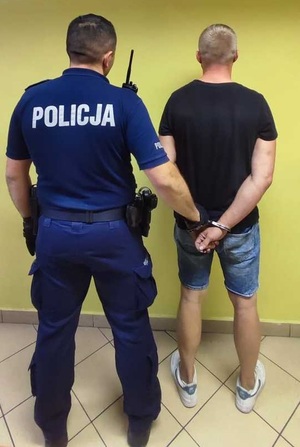 policjant z zatrzymanym mężczyzną