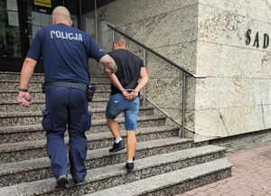 policjant z zatrzymanym mężczyzną