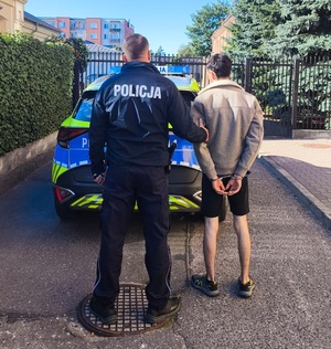 policjant z zatrzymanym mężczyzną