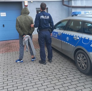 policjant z zatrzymanym mężczyzną