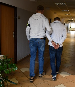 policjant z zatrzymanym mężczyzną