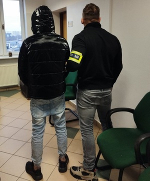 policjant z zatrzymanym mężczyzną